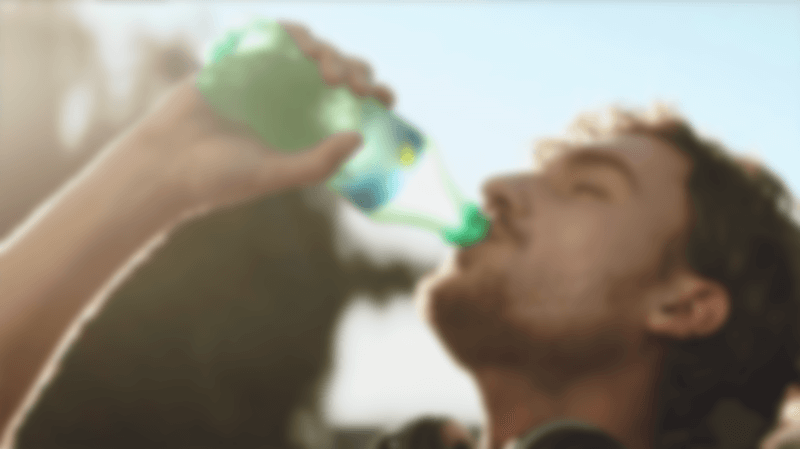 Man drinking a bottle of Sprite